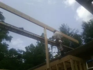 Carpenter setting a ridge beam over a new addition frame — Ice Dam Removal by Roofing Brothers in Harcourt