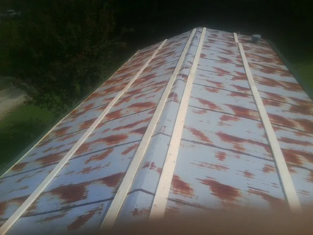 Rusted metal roof panels with new wood purlins before replacement — Storm Damage Roof Repair in Harcourt by Roofing Brothers