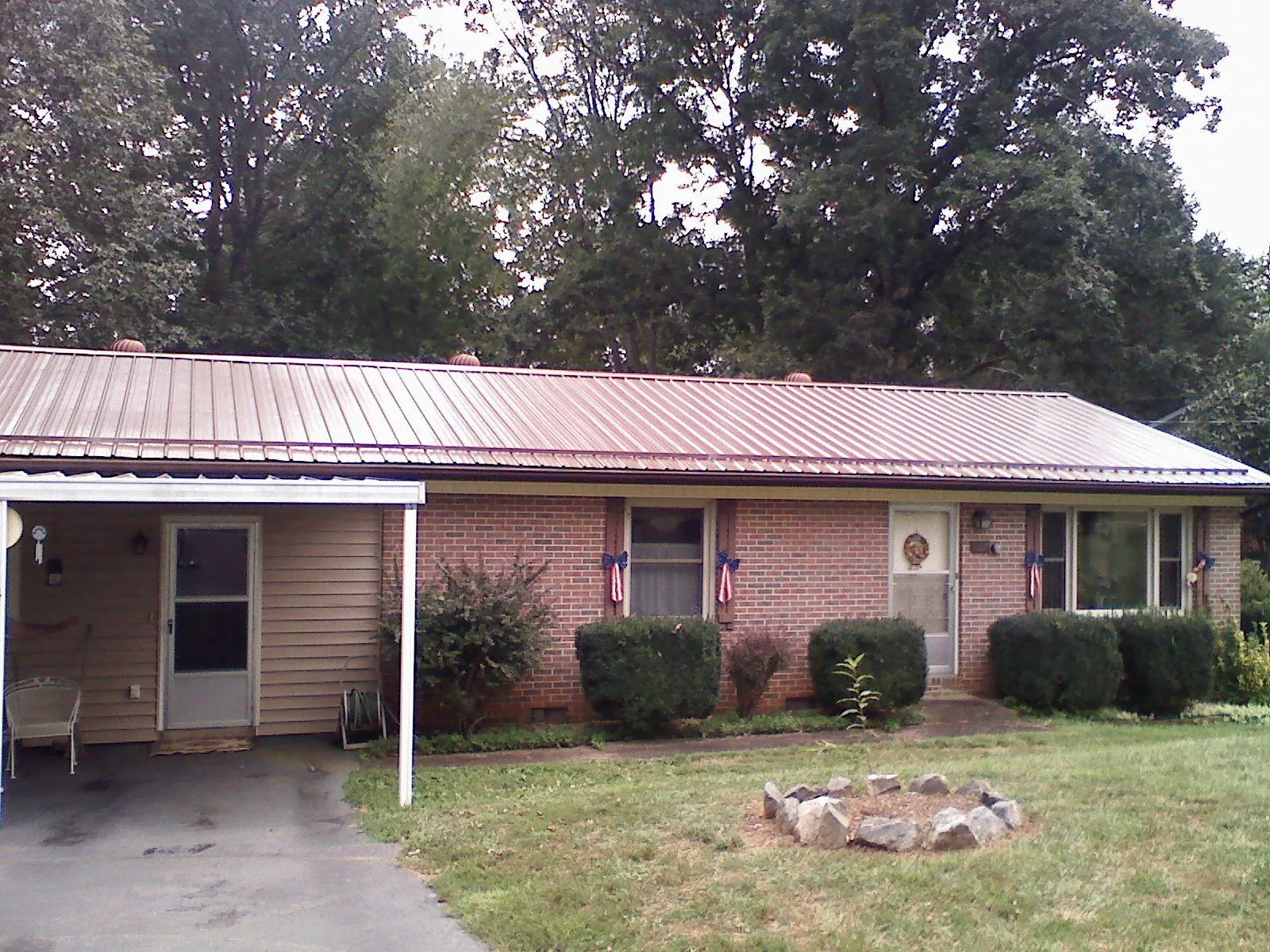 Bronze metal roof and carport on a brick ranch home — Roof Repair work by our crew in Harcourt