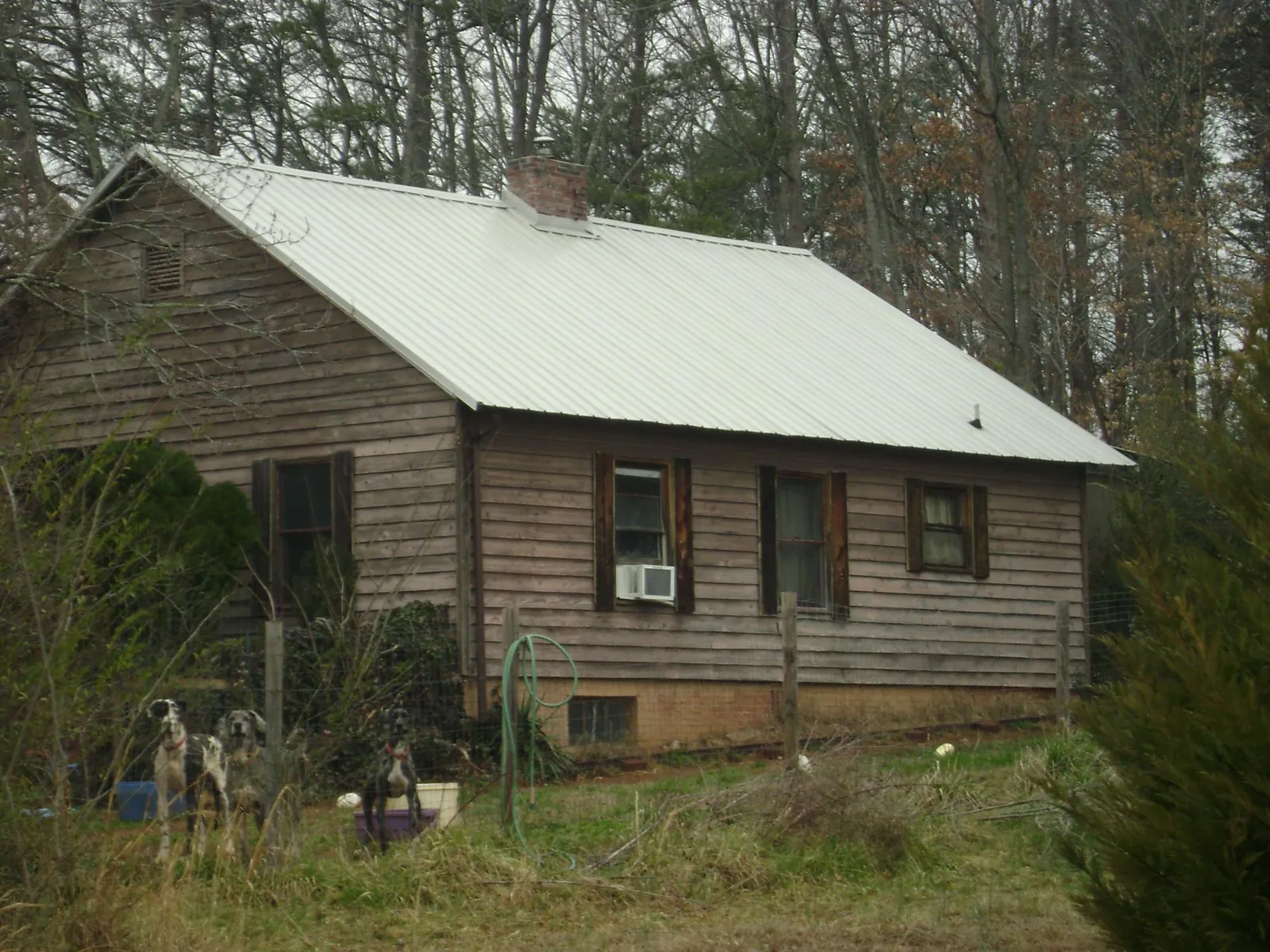 White metal roof on an old wood sided farmhouse, from a Metal Roof Installation job in Harcourt